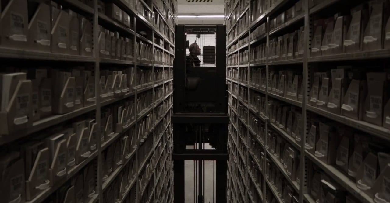 A "book picker" retrieving a book from the shelves of the Harvard Depository in the "Cold Storage" documentary (all screenshots by the author for Hyperallergic)