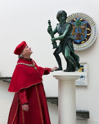 Actor Paul Jesson as Cardinal Wolsey with the reunited four bronze angels (courtesy  Victoria and Albert Museum, London)