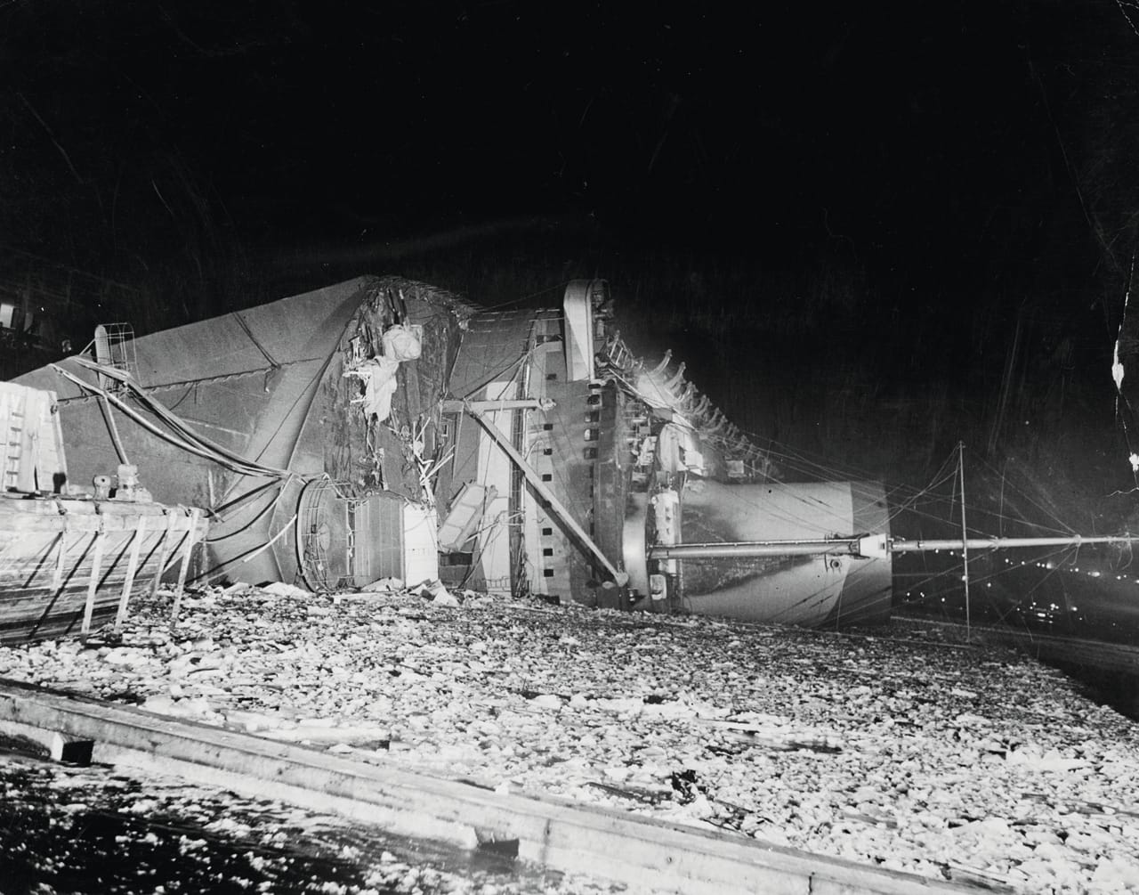 The Normandie capsizes after catching fire at Pier 88 in the Hudson River (February 10, 1942)