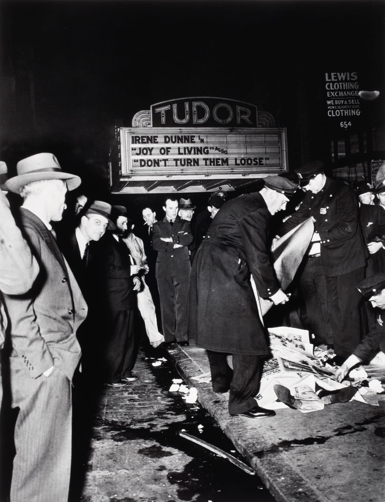 Police & bystanders with the body of a man killed in a car crash, 650 Third Avenue between East 41st & 42nd streets (April 16, 1942)