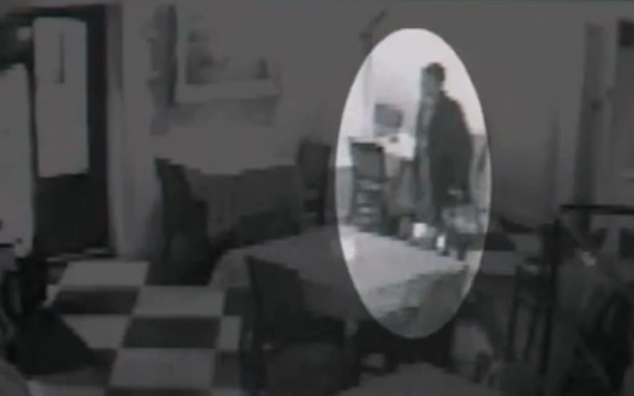 Security camera footage of an art thief walking out of Flip's Wine Bar and Trattoria. (screenshot by the author)