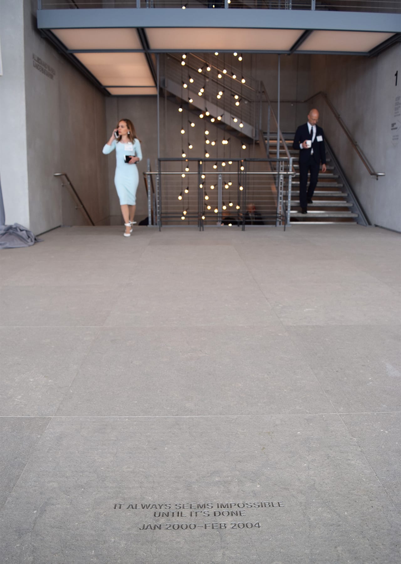 An inscription in the lobby floor and the staircase leading up to the galleries