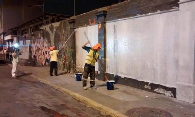 Workers remove a mural (Image via Twitter) 