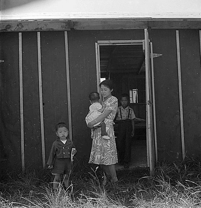 Stockton, CA, May 19, 1942. A family in front of their barracks, Stockton Assembly Center, California (Photographed by Dorothea Lange, WRA / Courtesy of the National Archives and Records Administration (National Archives Identifier 537735))