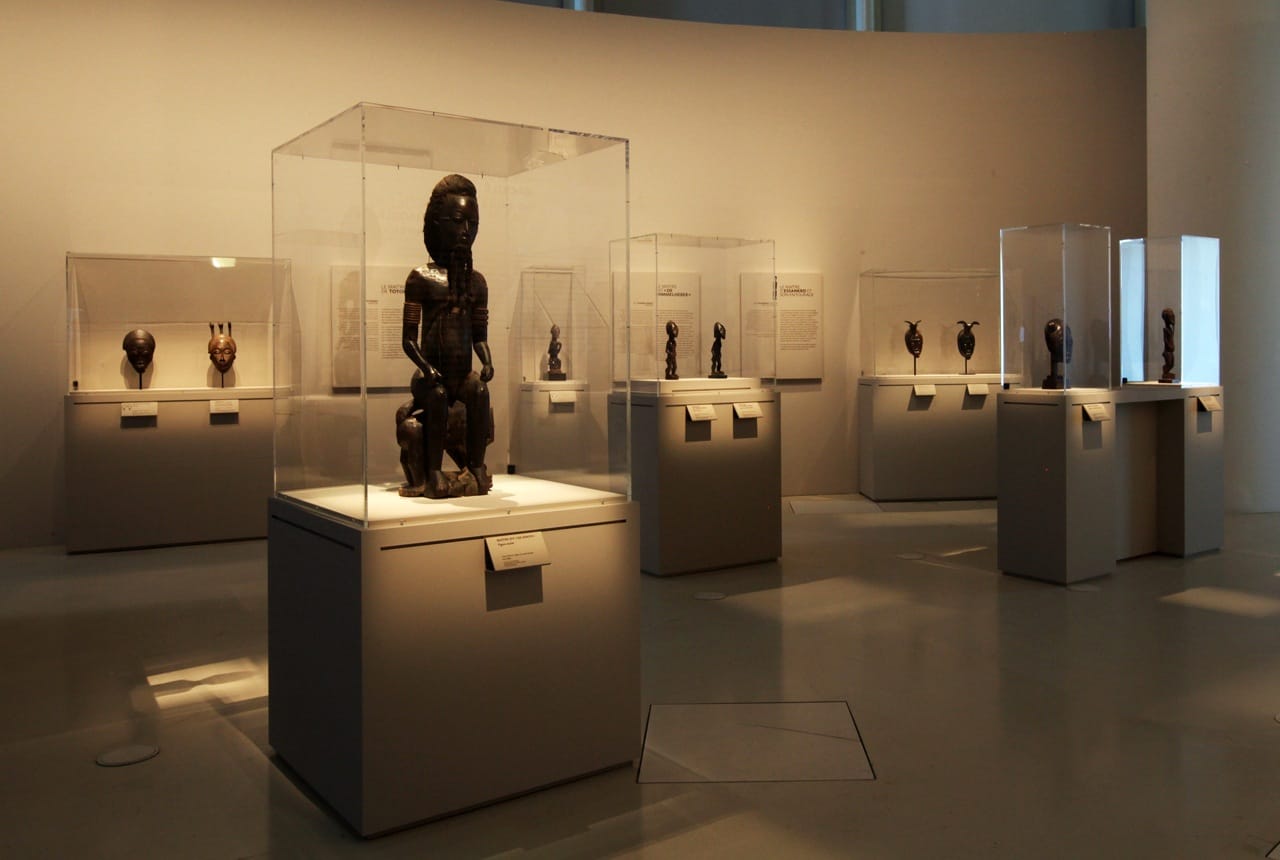 MusÈe du quai Branly. Affiche de l'exposition "Les maÓtres de la sculpture de CÙte d'Ivoire". Du 14 avril au 26 juillet 2015. Galerie Jardin.  Vue de l'exposition. RÈunissant prËs de 200 oeuvres historiques et contemporaines, l'exposition met ‡ l'honneur les grands sculpteurs et les Ècoles de sculpture de CÙte d'Ivoire et de ses pays limitrophes. Elle resitue les sculptures dans le contexte religieux et stylistique des Ateliers du 19e et dÈbut du 20e siËcle, notamment chez les SÈnoufo, les Lobi, les Dan ou encore les BaoulÈ, en les considÈrant sous l'angle de leur force esthÈtique et de la singularitÈ de leur crÈateur. L'exposition prÈsente Ègalement des installations et oeuvres d'artistes contemporains: la nouvelle gÈnÈration d'artistes africains ´ transnationaux ª, hÈritiËre des grands artistes du passÈ, met en avant la continuitÈ crÈative des sculpteurs d'Afrique de l'Ouest dans la pÈriode postcoloniale.