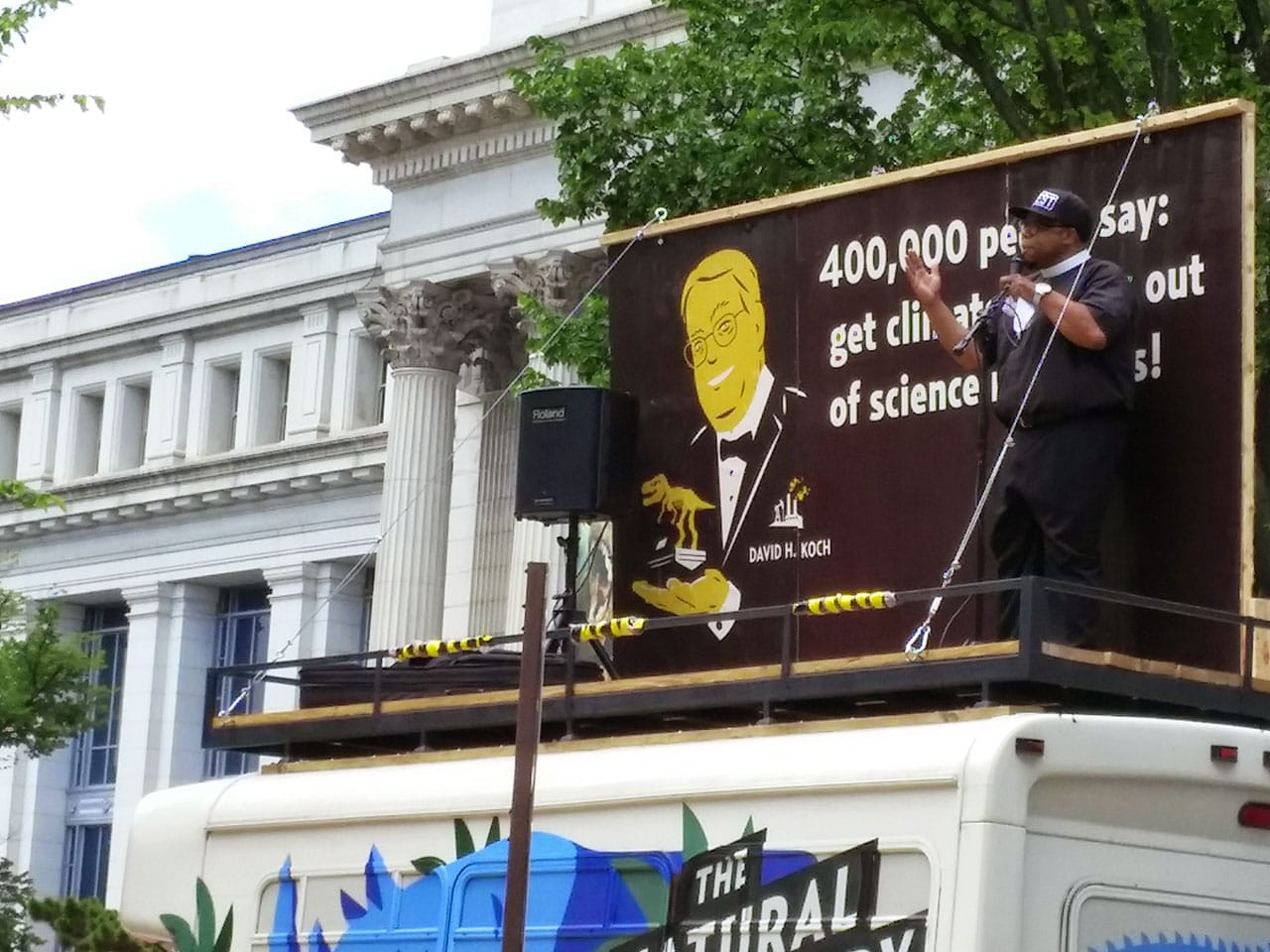 Reverend Lennox Yearwood speaks to anti-Koch demonstrators from the top of The Natural History Museum's van.
