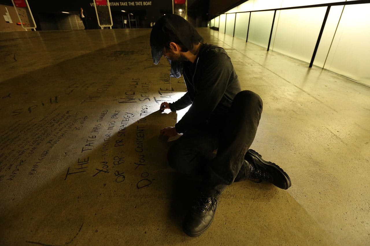 A Liberate Tate activist performing in the dark.