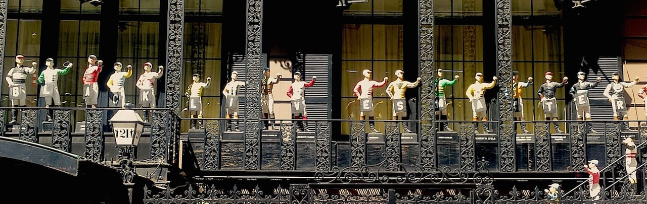 The balcony of the 21 Club with Never 21's signs around the jockey statues' necks. (photo by Keegan Stephan, used with permission)