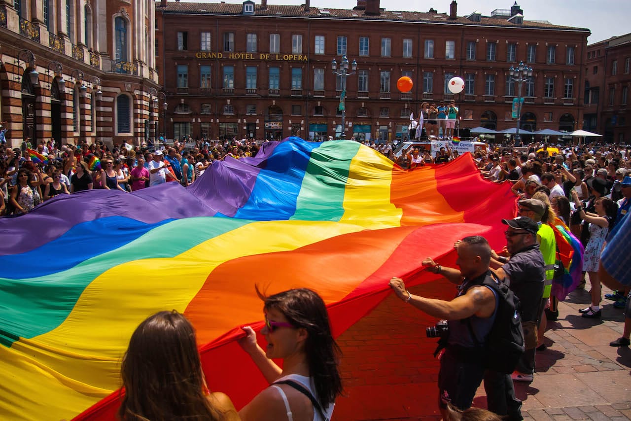 A giant Rainbow Flag at the Gay Pride Parade in Toulouse in 2014 (photo by Pablo029, via Wikimedia Commons)
