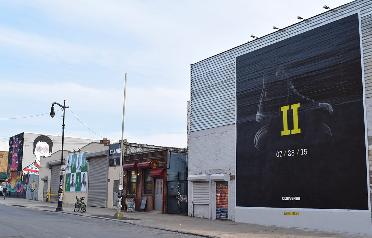A large painted billboard on Wyckoff Avenue amid the Bushwick Collective murals. (all photos by the author for Hyperallergic unless noted otherwise)