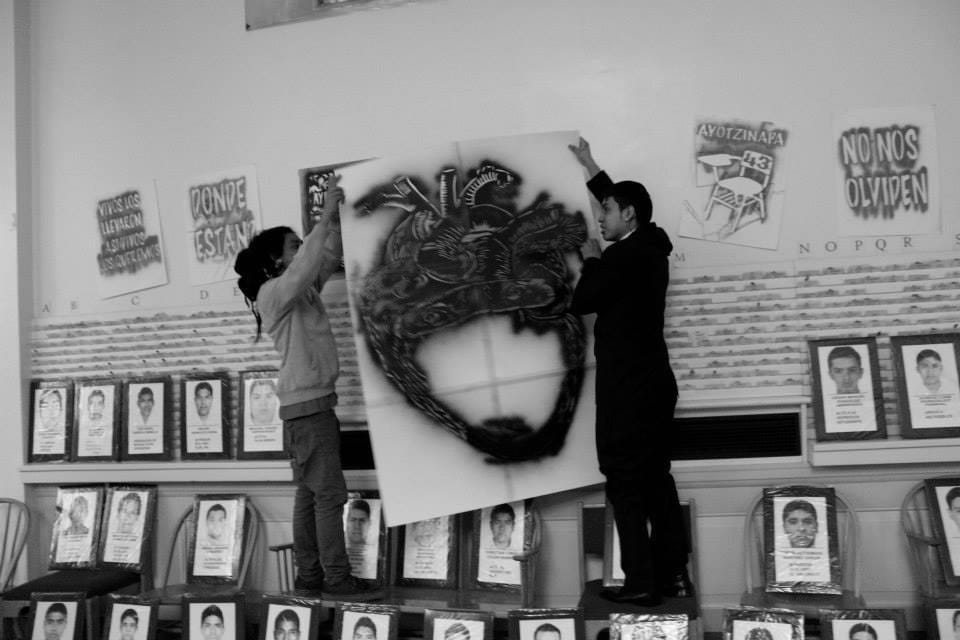 Emilio Zappa (left) holding one of his posters at a commemoration event for the disappeared students (photo by Beatriz Elena Lopez)