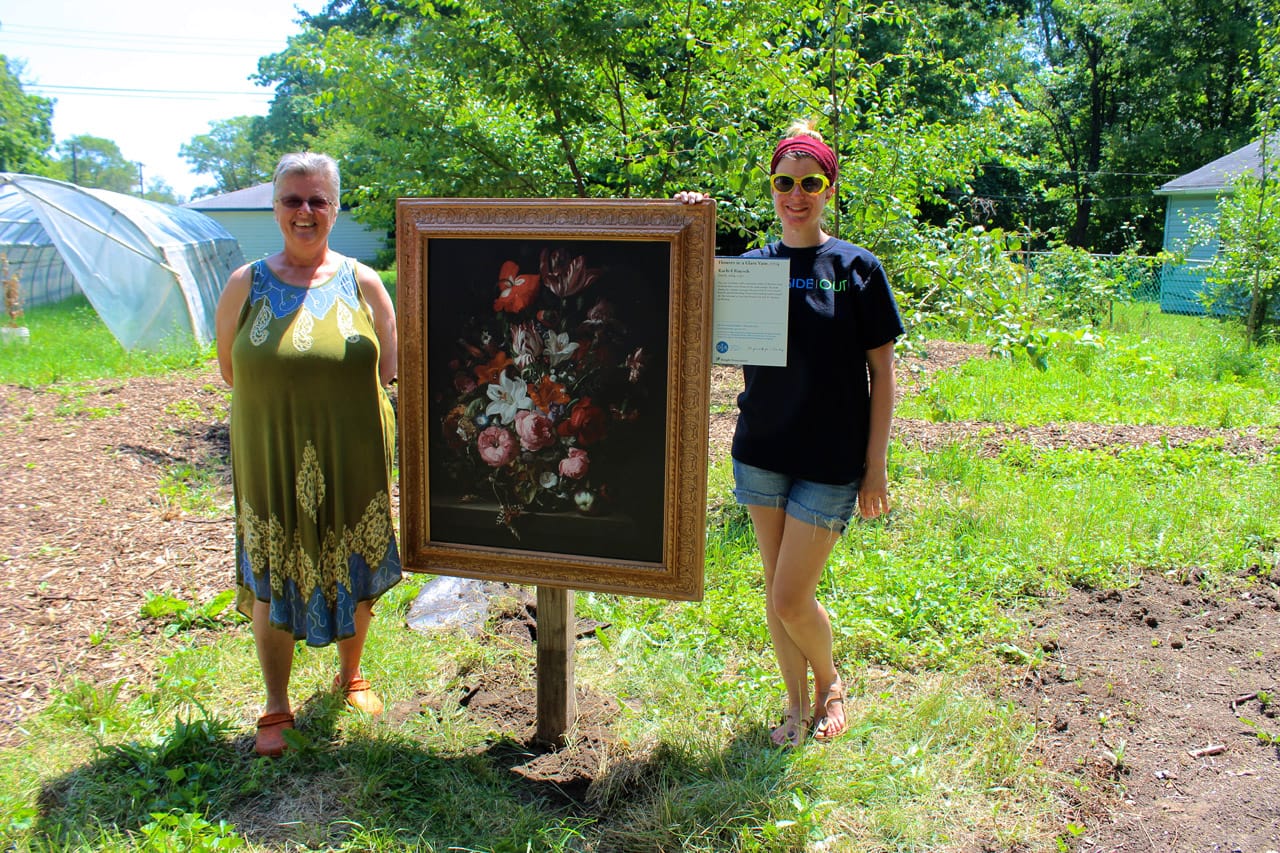 Schumack (left) and Reese (right) pose with a reproduction of "Flowers in a Glass Vase"