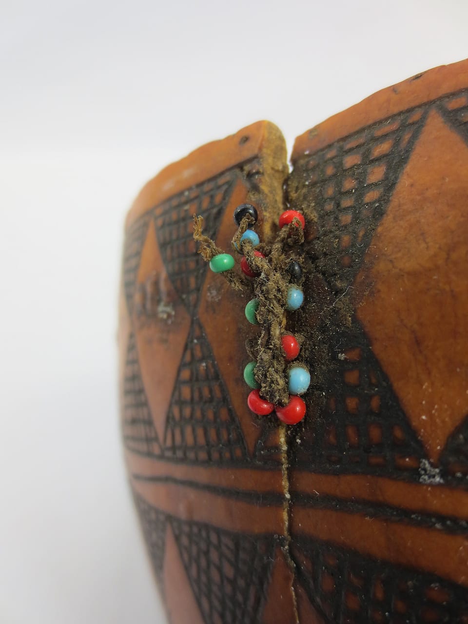 Gourd from South Sudan with a stitched plant fiber repair incorporating glass beads (1979) (courtesy Pitt Rivers Museum, University of Oxford)