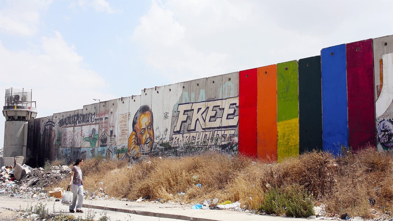 Khaled Jarrar’s rainbow mural “Through the Spectrum” painted on the Israeli separation wall near the Qalandiya checkpoint in the West Bank. (image courtesy Khaled Jarrar)