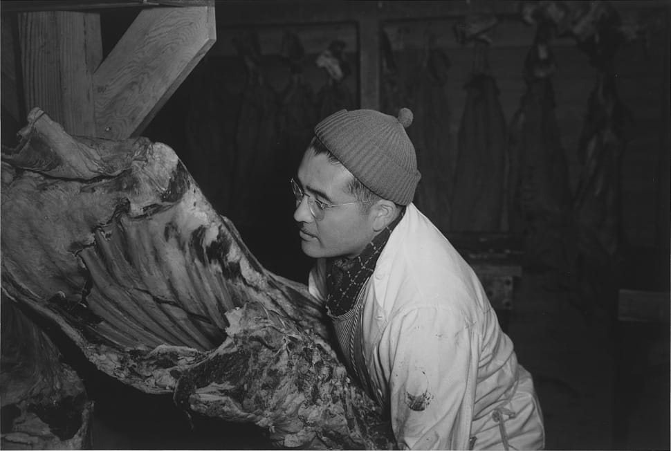 Ansel Adams, "Manzanar, CA, 1943" (1943). J.S. Yonai in the camp’s butcher shop, handling beef (photograph by Ansel Adams, courtesy the Library of Congress, Prints & Photographs Division [reproduction no. LC-DIG-ppprs-00310]) 