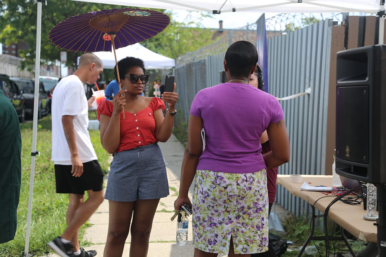 Vocalo DJ (left, with parasol) interviews CCJ warden Nneka Jones Tapia.