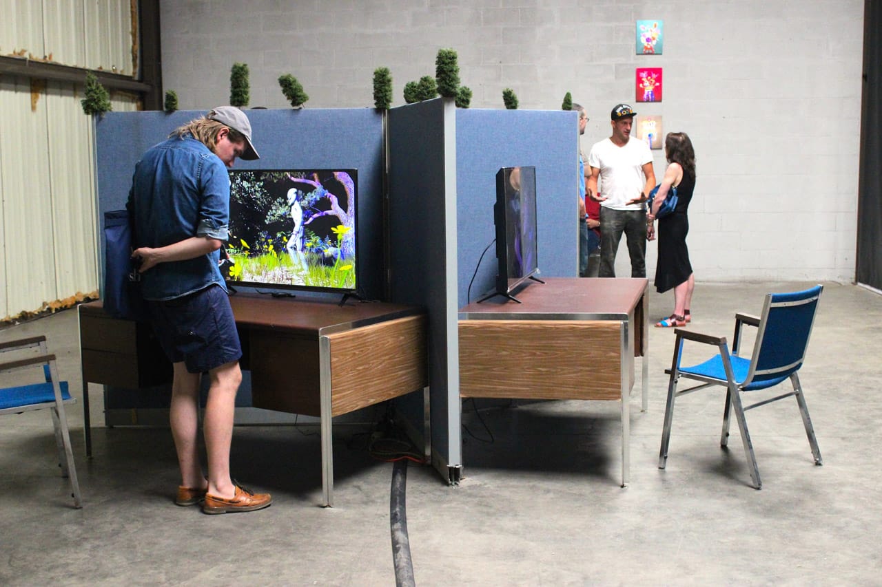 Gallery visitors chat with Youngworld organizers, and inspect the the offerings.