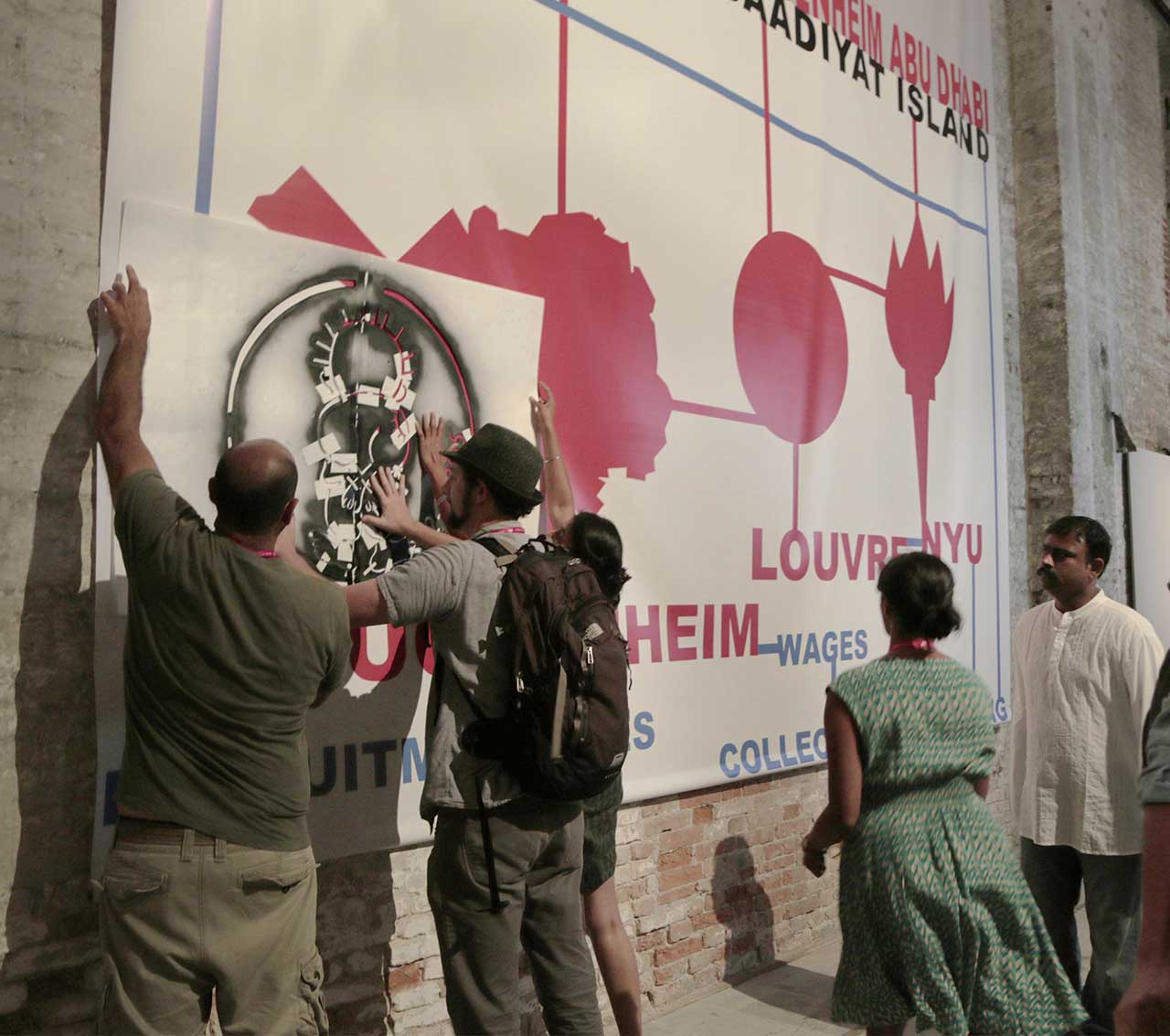 G.U.L.F. activists stenciling the Gulf Labor banner in the Arsenale half of the All the World's Futures exhibition