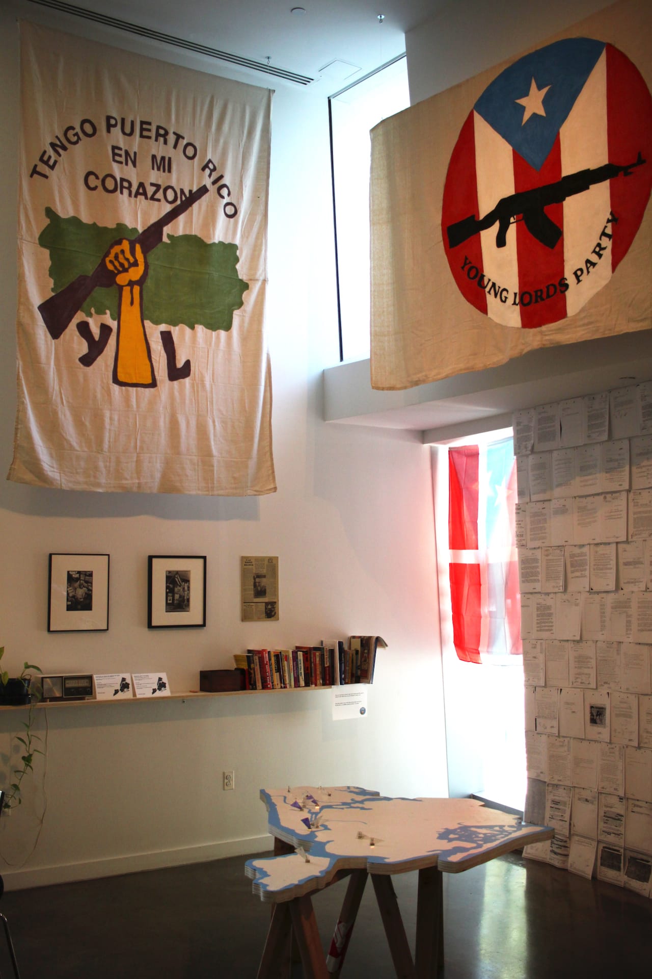 Two of the Young Lords’ Party flags draped above a map of New York City.