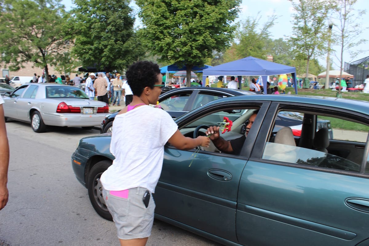 Tempestt Hazel, curator, writer, and artist advocate, hands out flowers to a passing community member in Bronzeville during the Black Love Procession on September 6, 2015 (click to enlarge)