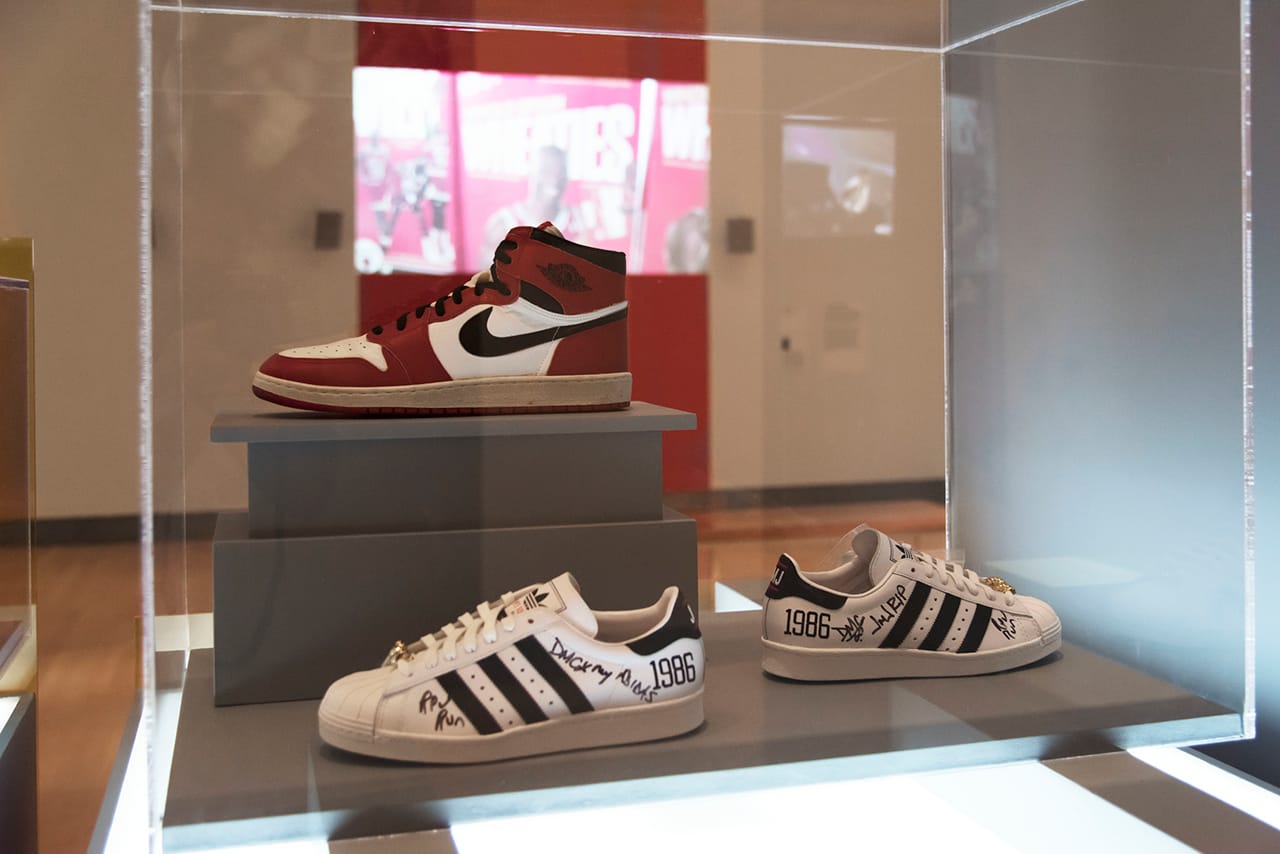 Installation view, 'The Rise of Sneaker Culture' at the Brooklyn Museum, showing Nike's Air Jordan I (1985) on top and the adidas x Run–DMC 25th Anniversary Superstar (2011) below (© Jonathan Dorado)