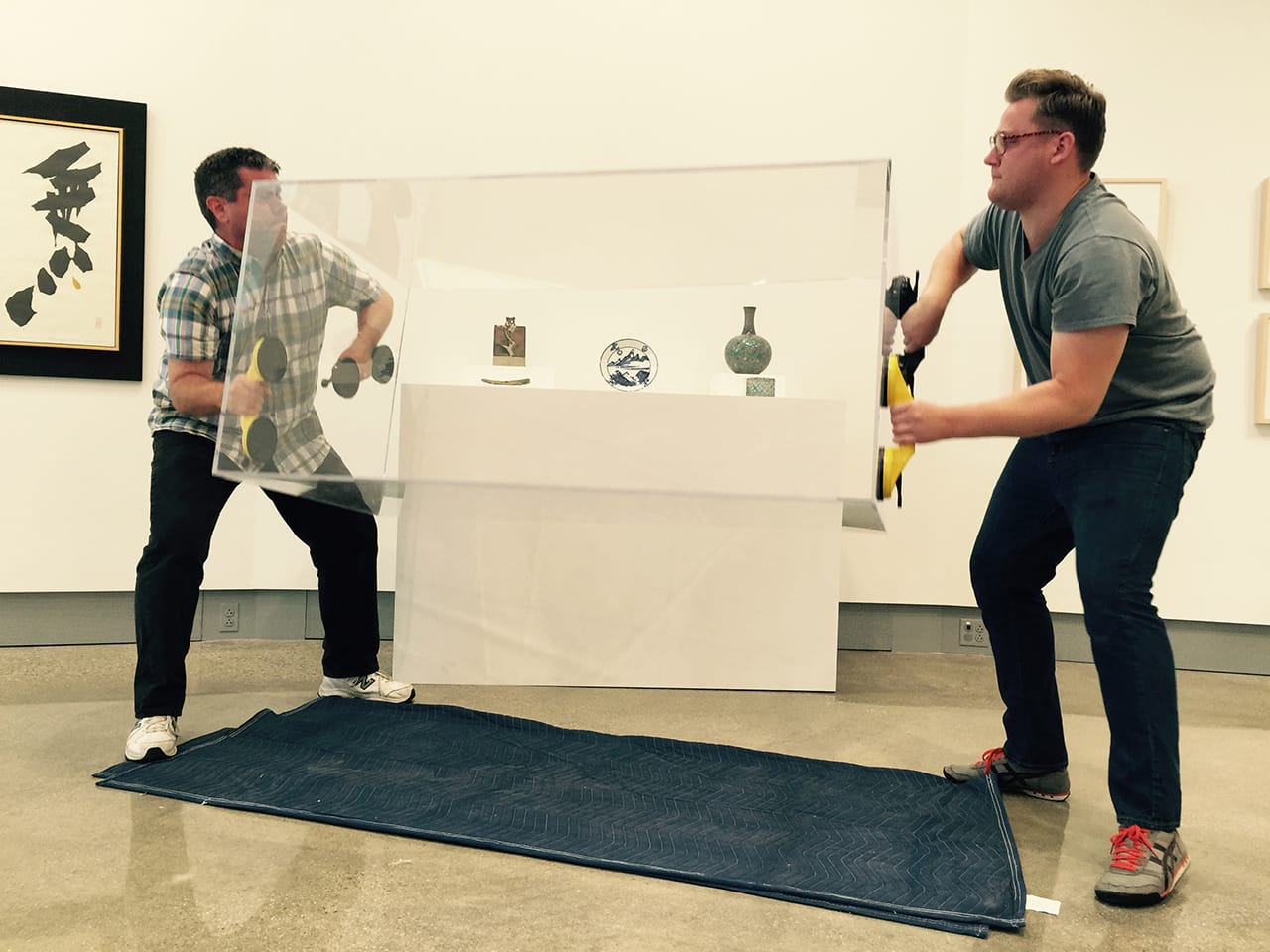 Kruizenga Director Charles Mason and preparator Evan Smeege lift a vitrine into place. (click to enlarge)
