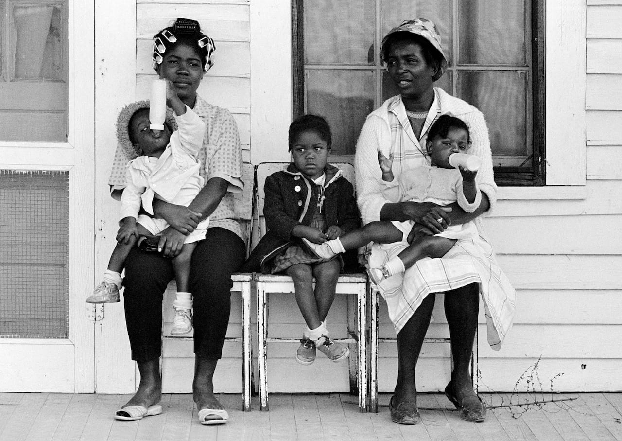 Stephen Somerstein, Two mothers with children watching marchers on porch, 1965. Courtesy of the photographer
