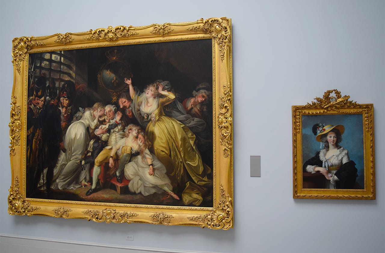 A gallery in the Wadsworth Atheneum's Great Morgan Hall devoted to the French Revolution, with Mather Brown's painting "Louis XVI Saying Farewell to his Family" (ca. 1793) on the left and Élisabeth Louise Vigée Le Brun's "The Duchesse de Polignac Wearing a Straw Hat" (1782) on the right