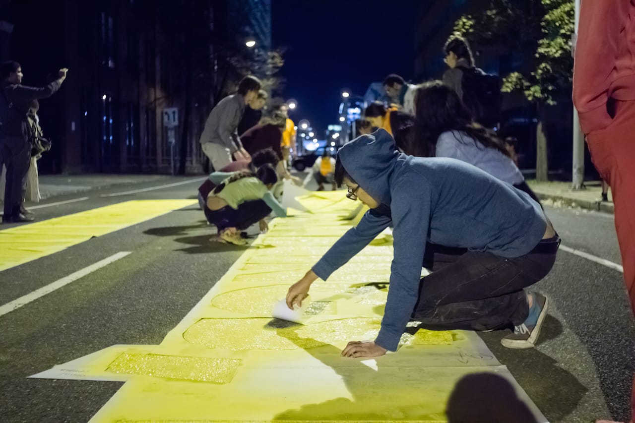 Volunteers and community members from Juntos help place "Somos Seres Humanos (We Are Human Beings)" on October 12 (photo by Jose Mazareigos)