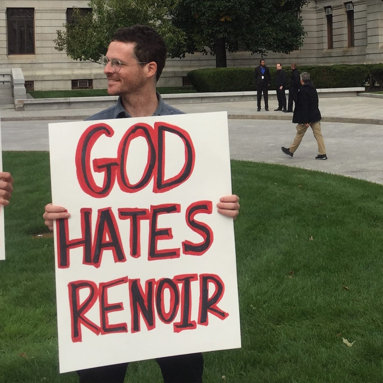 A protestor with a "God Hates Renoir" sign (click to enlarge)