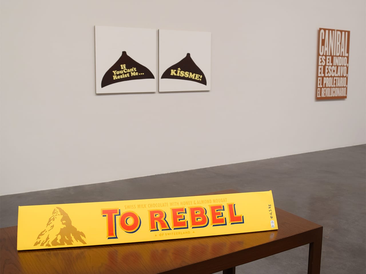 Installation view of Minerva Cuervas's 'Feast and Famine' with "To Rebel" (2015), acrylic on Toblerone cardboard case, in the foreground