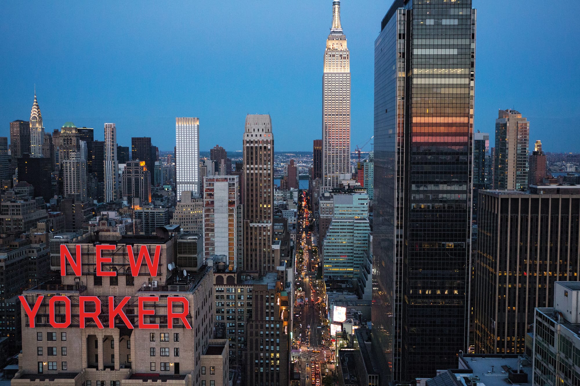 The New Yorker Hotel and view down W 34th Street towards the Empire State Building in New York City on an early evening in spring. The New Yorker Hotel on Eighth Avenue and 34th Street was the largest in New York when it opened in 1930. In the days when the well-heeled traveler from Chicago and the West debarked from the Pennsylvania Railroad‚Äôs Broadway Limited express train at Pennsylvania Station across the street, the Art Deco hotel sat on top of the world. The rise of air travel, the demolition of the station, and the decline of the neighborhood all led to one conclusion, and in 1972 it closed its doors. But in New York, everything comes around again: It is, after many vicissitudes, once again an up-and-coming hotel, and while it may not be New York‚Äôs chicest, it can claim the best sign.