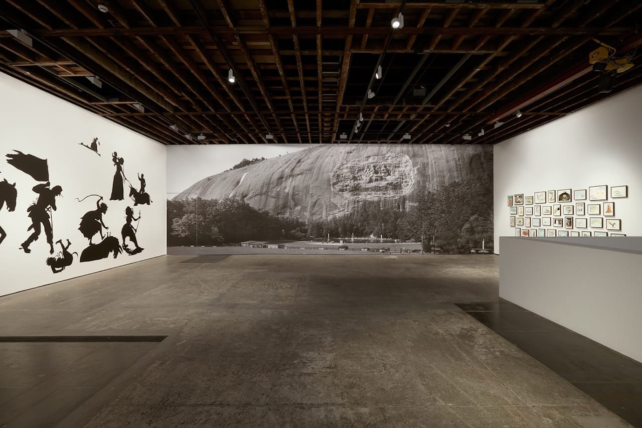 Installation view of upstairs gallery with photographic mural by Walker and filmmaker Ari Marcopoulos, (photo courtesy Victoria Miro Gallery)