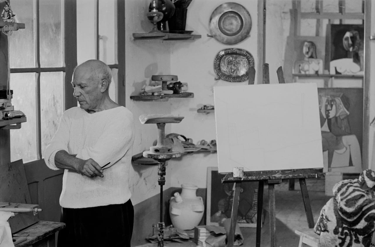 (Bild Variante 2, anderes Dach) Picasso doing a charcoal drawing of the view from Le Fournas. Lucien Emmer Film. Vallauris 26.6.53. On the wall behind it "Bust of a Woman". Vallauris 26.6.53. Die Entstehung einer der zahlreichen Landschaftszeichnungen von Vallauris mit dem Kontrast zwischen der Geometrie der Hänge, der elektrischen Leitungsdrähte und den Rauchkringeln, die aus den Öfen der Keramiker entweichen. Vallauris 26.6.53.