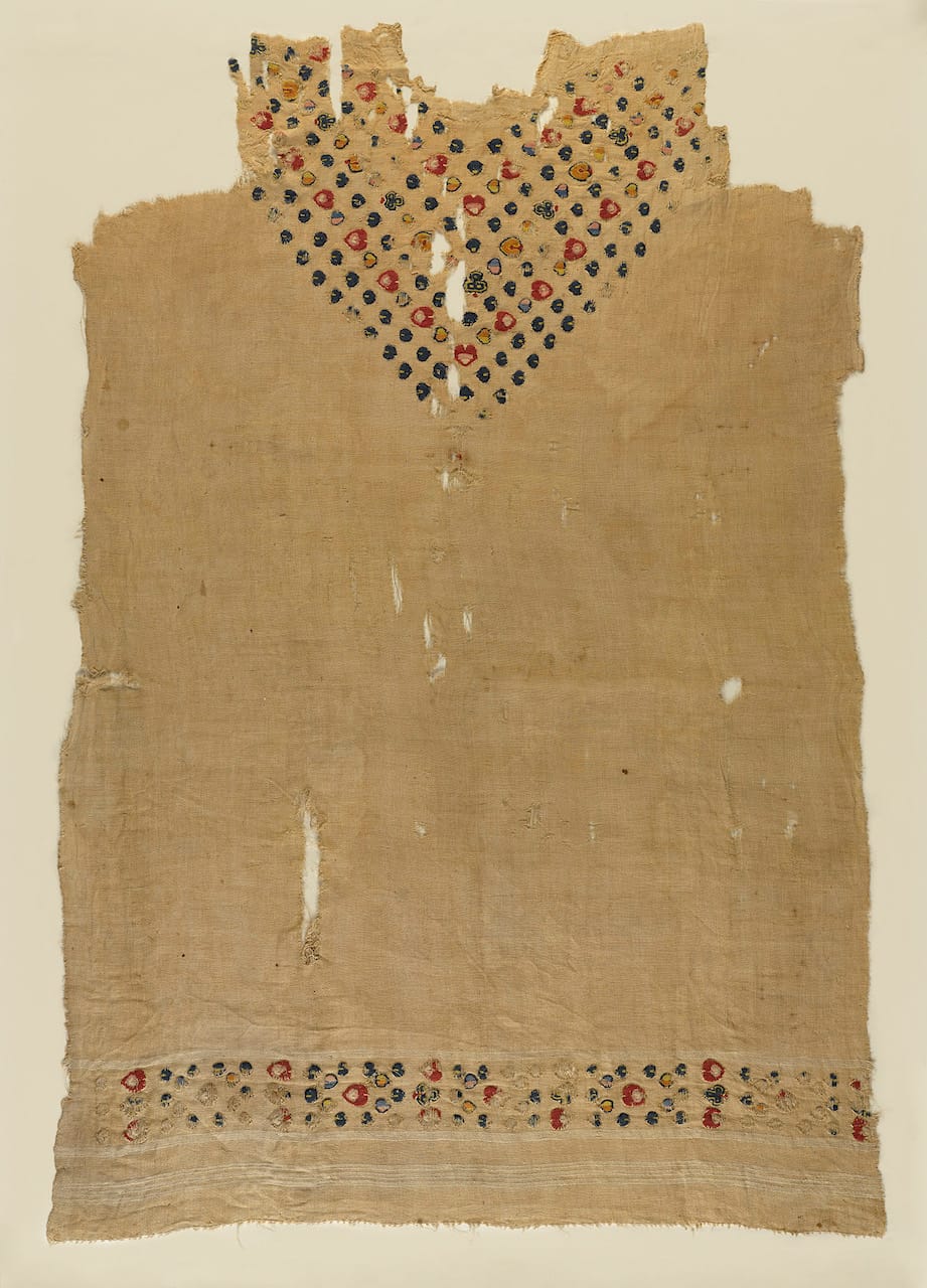 Tunic with floral motifs at neck and bottom edge, plain (tabby) ground weave, tapestry band of dyed wools of floral motifs at lower edge and forming “v” at neck (Egypt, c5th –6th century CE) (© Brooklyn Museum, photo by Sarah DeSantis)