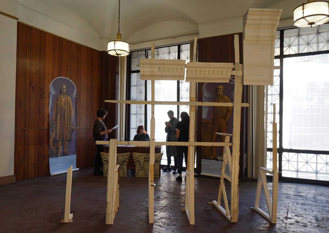 Installation view of 'Bulldoze/Cement,' featuring a sculpture by Sonya Blesofsky in the foreground and paintings by Susan Hamburger in the back