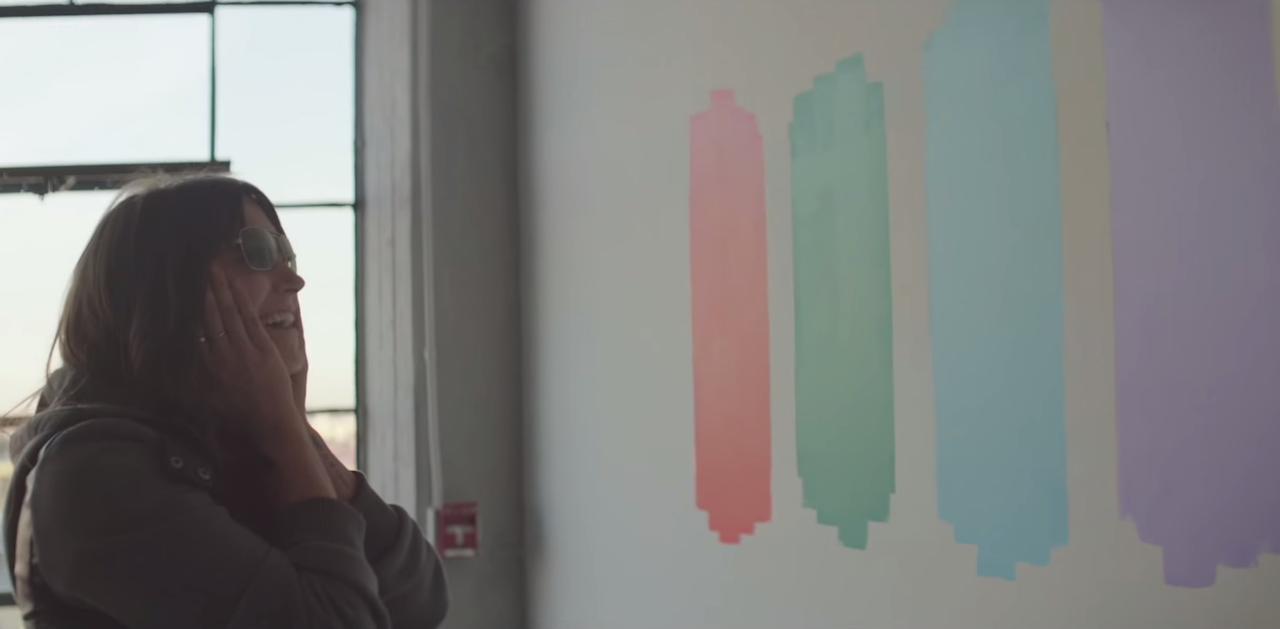 A woman experiences EnChroma's color blindness-correcting glasses, which the report notes are provided to color-blind visitors at the Museum of Contemporary Art, Chicago upon request (screenshot via YouTube)