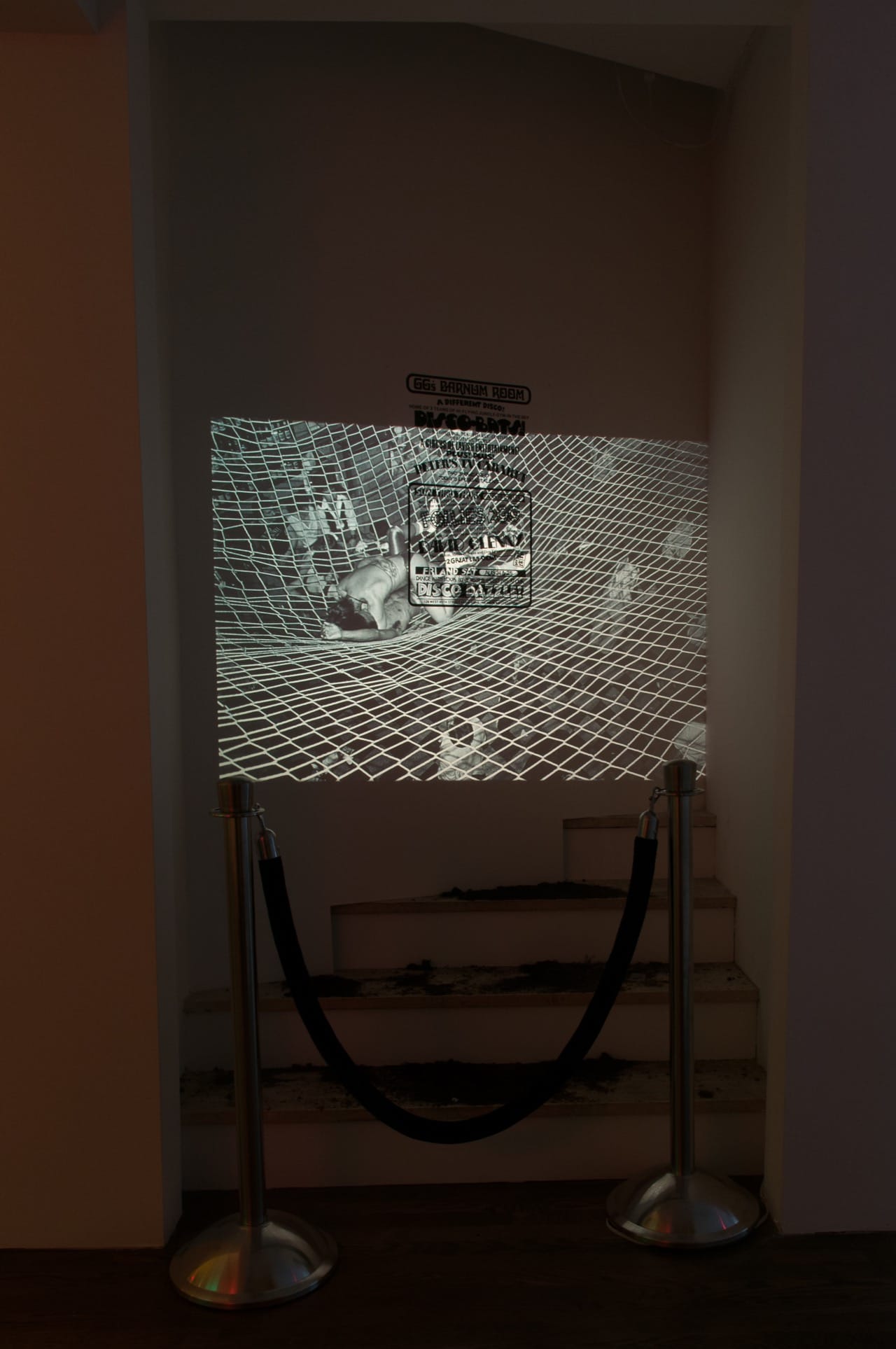 Hilton Als, Dirt Nap/Disco Nap, 2016, dimensions variable, slide projector, black velvet rope with stanchions, GG’s Barnum Room poster; Projected slide: Bill Bernstein, GG’s Barnum Room, Disco Bats on Net, 1979, dimensions variable, 35mm slide transfer