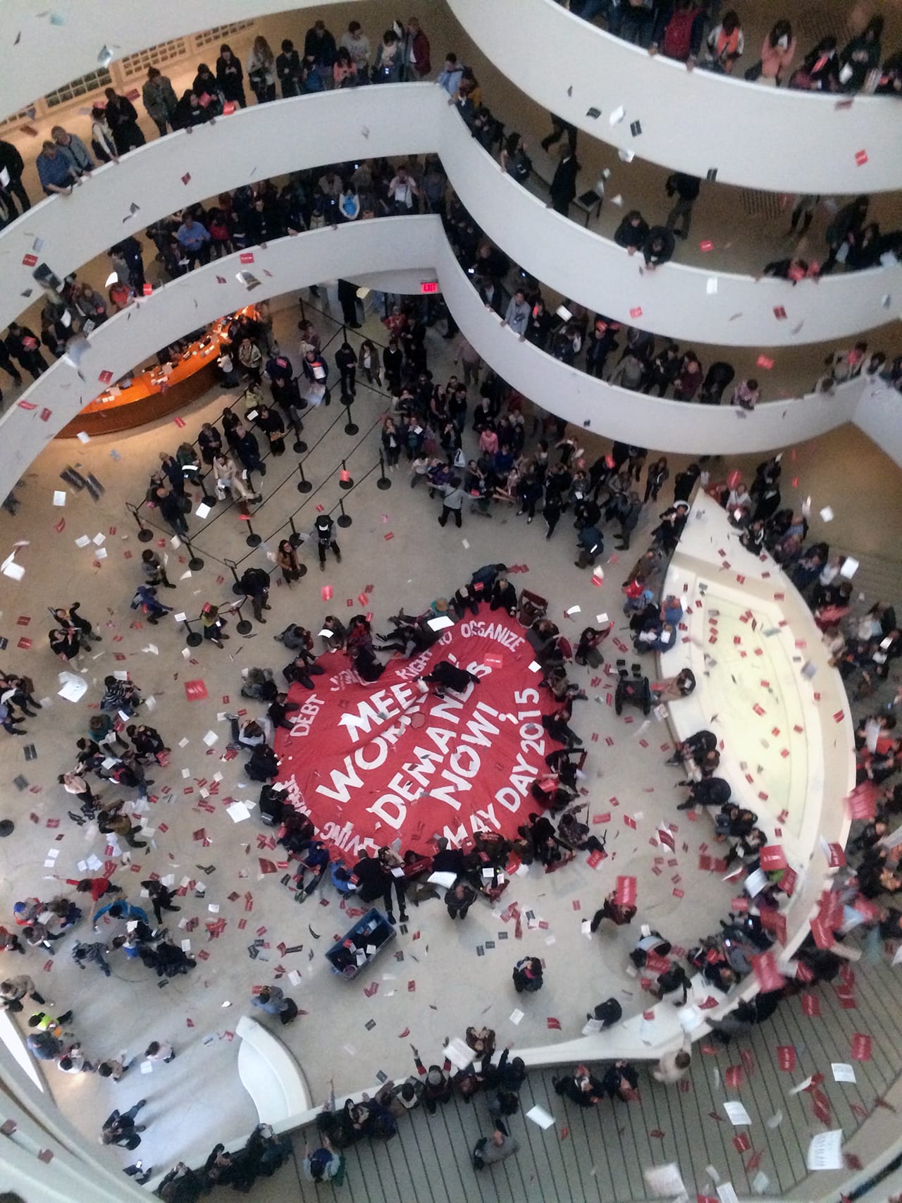 On May Day 2015, members of the Gulf Ultra Luxury Faction (G.U.L.F.) unveiled a large parachute in the Guggenheim Museum rotunda with the words “Meet Workers Demands Now” (image Benjamin Sutton/Hyperallergic)