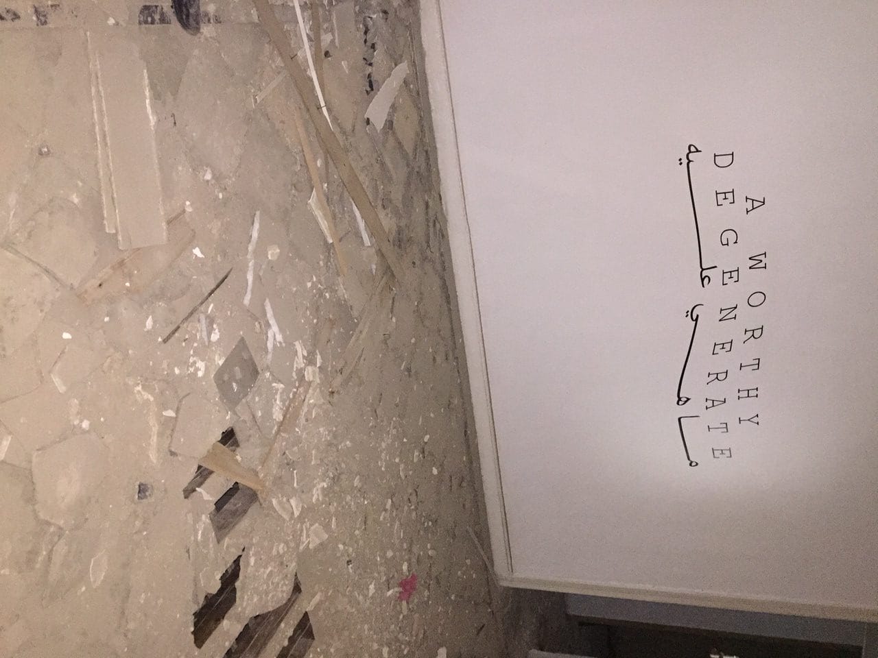 Inside Townhouse Gallery's main building, with its floors destroyed and the wall text from last exhibition still on the walls.