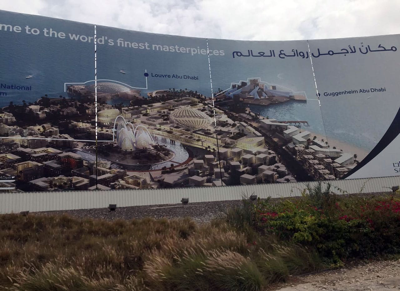 A billboard on Saadiyat Island, Abu Dhabi, advertises several of the museum projects as The World’s Finest Masterpieces, including the Guggenheim Abu Dhabi on the top right. (photo by the author for Hyperallergic)