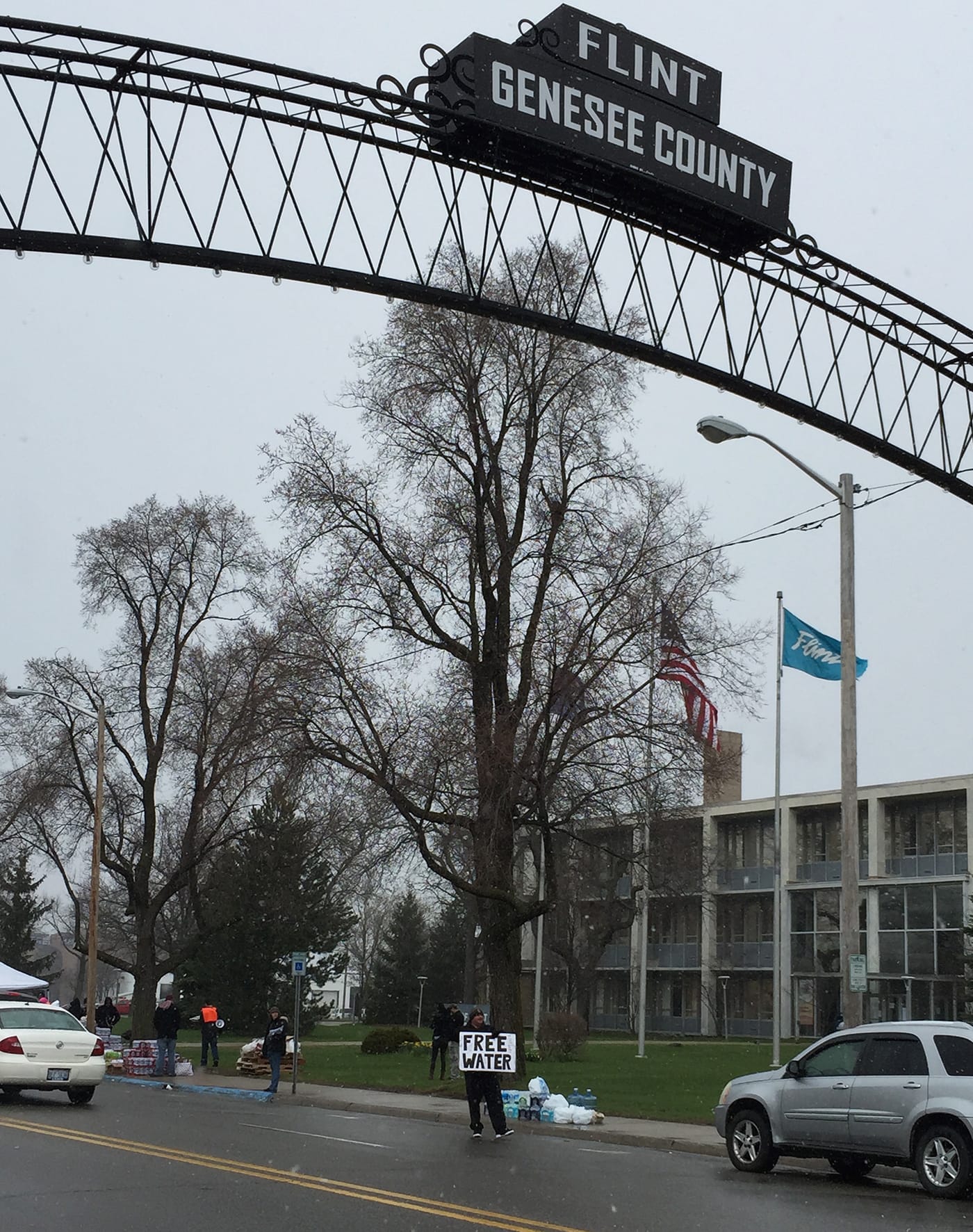 A water distribution point is located at the south end of Saginaw Street, the main thoroughfare in downtown Flint. The arch (echoed by another, placed at Saginaw Street’s north end) recreates one of two that originally spanned the street between 1899 and 1919. In the background, the midcentury modern architecture of City Hall reflects Flint’s heyday. (all photos by the author for Hyperallergic unless otherwise noted)