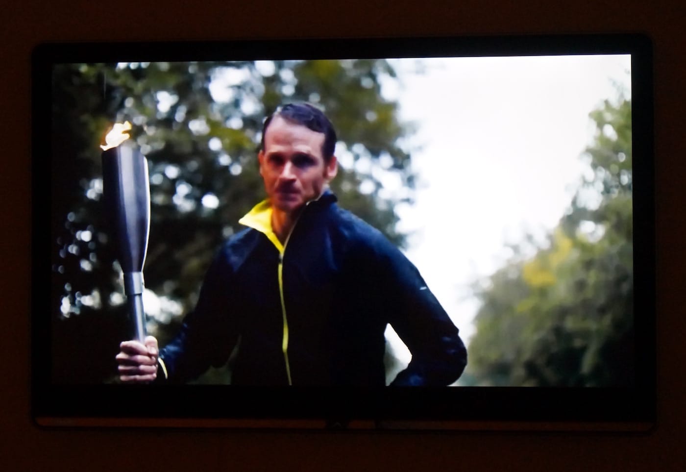 A white man bears a torch for freedom in a political ad for something American.