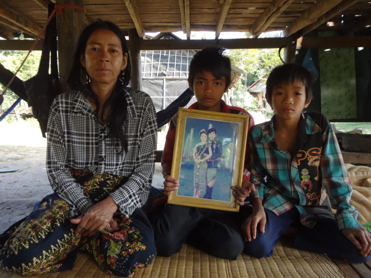 NAME showing her wedding photograph with her two sons. All images provided by the gallery and PierSath.