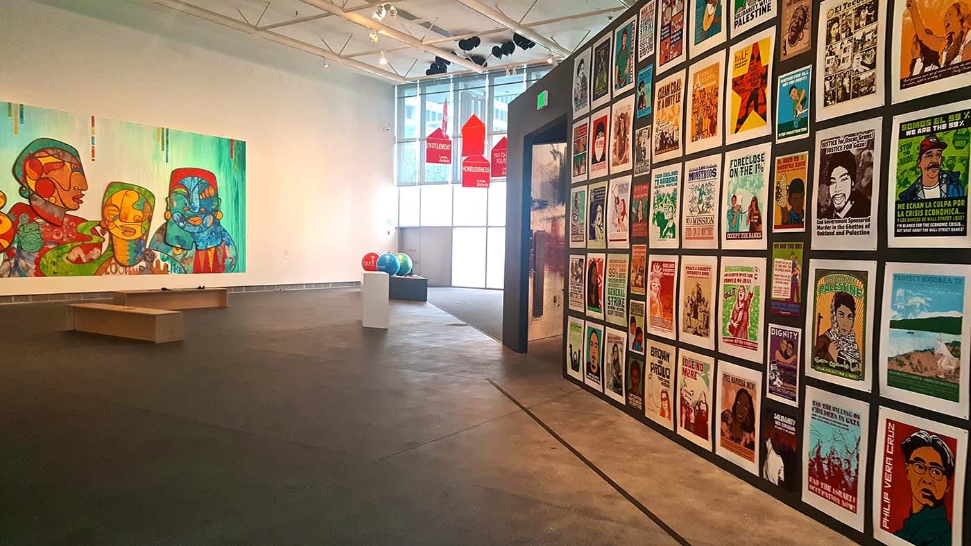 Foreground: Dignidad Rebelde, Selected Works, 2007-15, Seventy screen prints, fifteen digital prints and one offset print; Background (left): Favianna Rodriguez, Pleasure is Freedom, 2016, Site-specific mixed-media, CNC-milled wood
