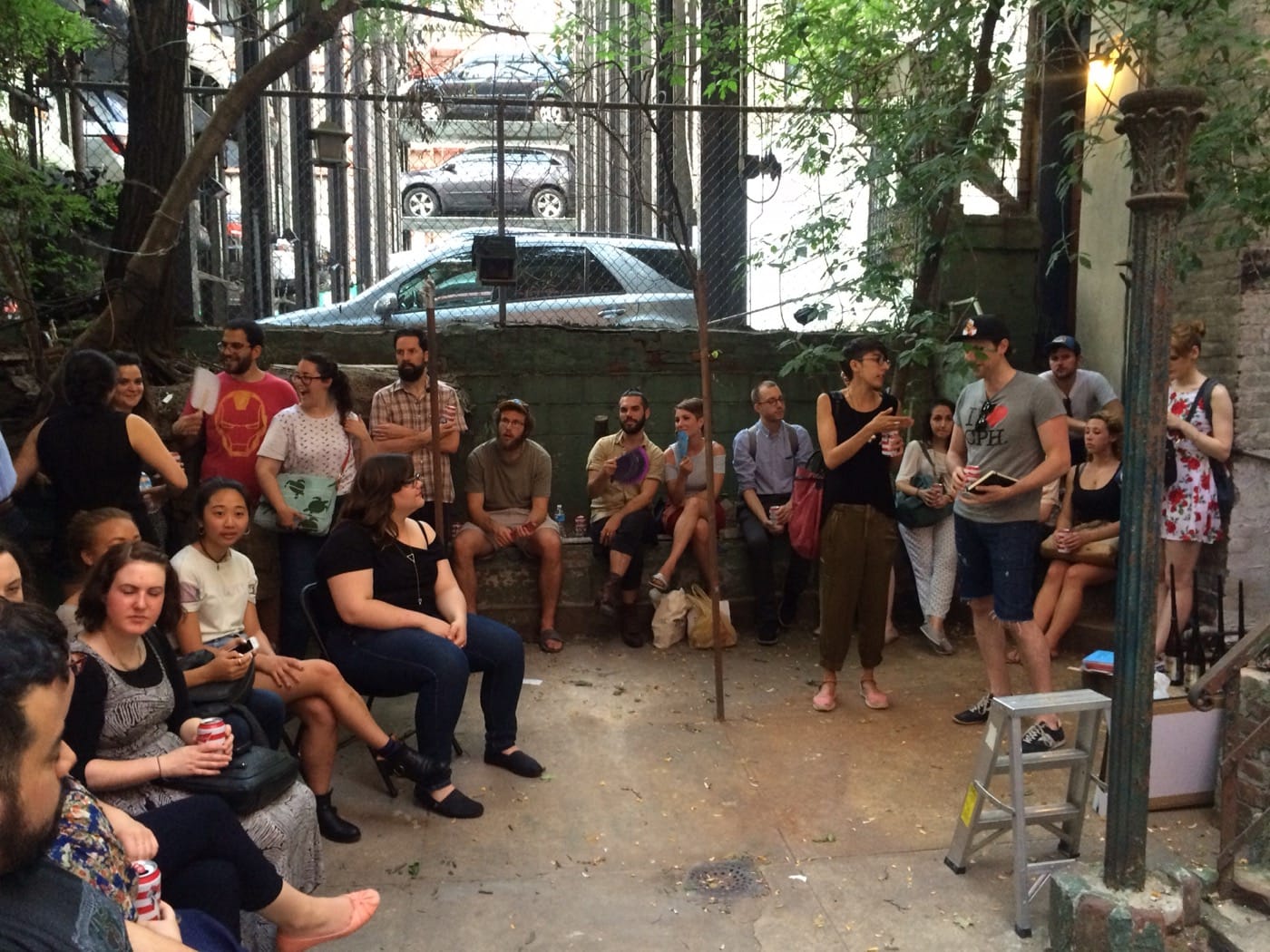 Audience at performance by Beau Torres in the Baxter St CCNY backyard 