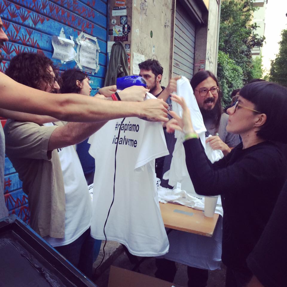 Peope silkscreening T-shirts that say #riapriamoildalverme (Reopen DalVerme)