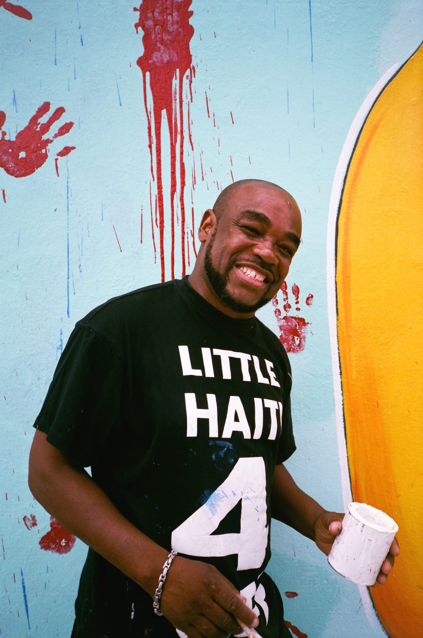 Serge Toussaint working on his mural "Anpil Min Chay pa Lou"