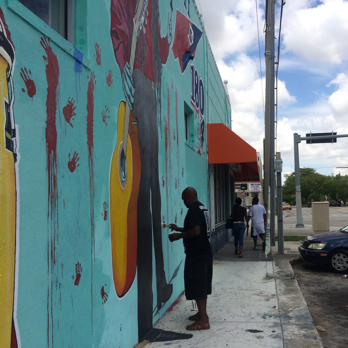 Serge Toussaint working on his mural "Anpil Min Chay pa Lou"