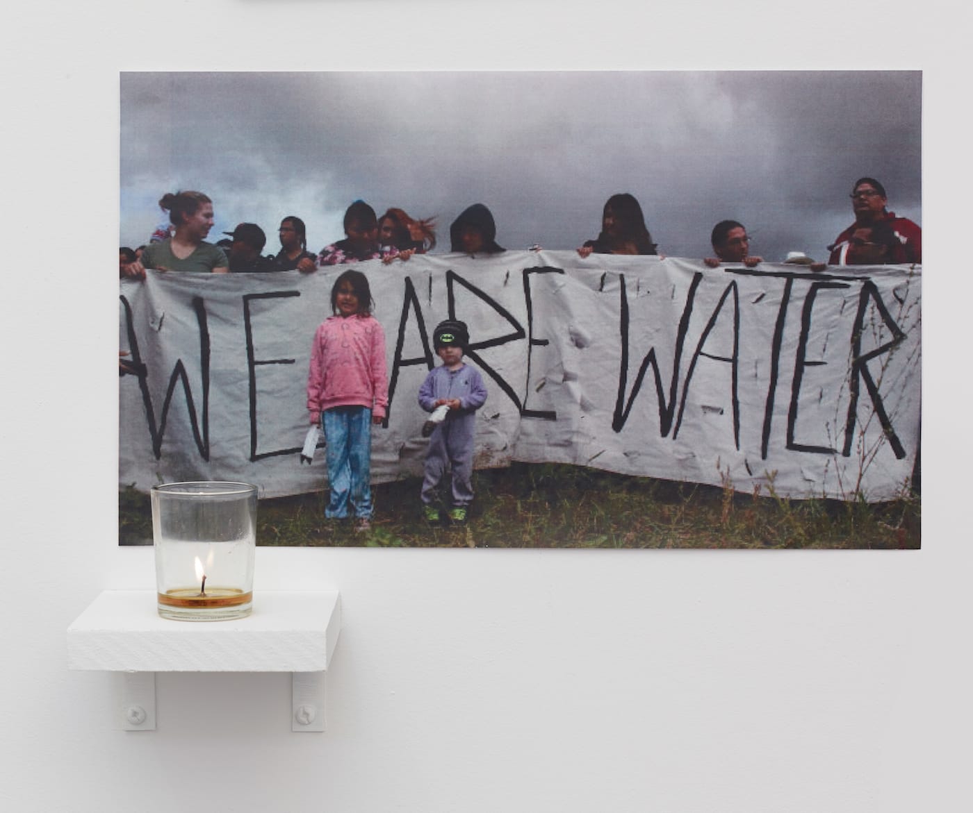 A.L. Steiner, "War is peace. Freedom is slavery. Ignorance is strength." (2016), 30 color photocopies, candle, wood shelf, dimensions variable